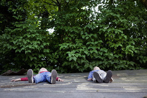 Deutschland, Nordrhein-Westfalen, Köln, Jungen entspannen sich auf einem Spielplatz, lizenzfreies Stockfoto