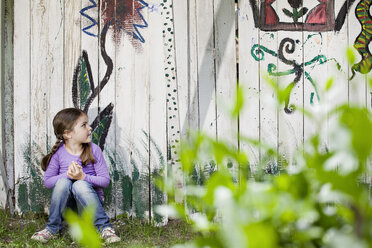 Germany, North Rhine Westphalia, Cologne, Girl sitting in playground - FMKYF000393