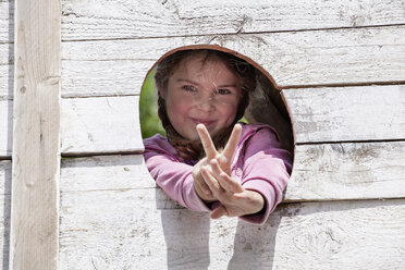 Deutschland, Nordrhein-Westfalen, Köln, Porträt eines Mädchens mit V-Zeichen, lächelnd - FMKYF000387