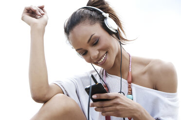 Deutschland, Junge Frau hört Musik mit Kopfhörern, lächelnd - GDF000098