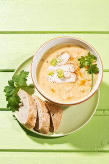 Bowl of soup with carrots, spring onions, cabbage and bread on plate - MAEF006847