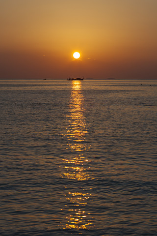 Asien, Sonnenuntergang mit Fischerboot am Indischen Ozean, lizenzfreies Stockfoto