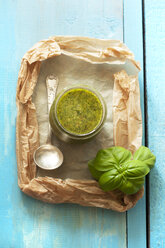 Basil pesto with ladle on wooden table, close up - OD000135