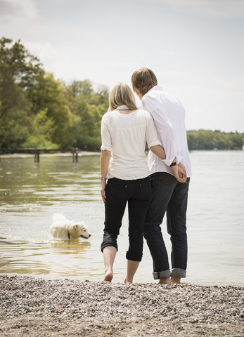 Deutschland, Bayern, Junges Paar mit Hund im See, lizenzfreies Stockfoto