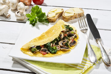 Omelett mit Pilzen auf Holztisch - MAEF006895