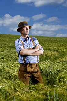 Germany, Bavaria, Farmer standing in field with arms crossed - MAEF006906