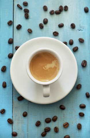 Espresso mit Kaffeebohnen auf Holztisch, Nahaufnahme, lizenzfreies Stockfoto