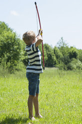 Germany, Bavaria, boy playing with bow and arrow - NH001383