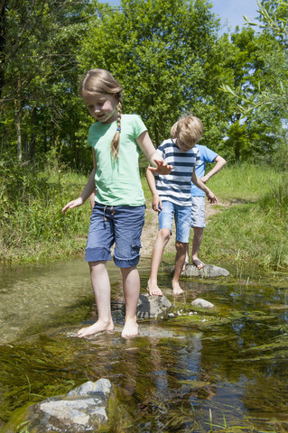 Germany, Bavaria, Munich, Friends walking in creek stock photo