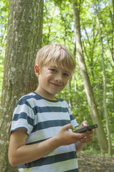 Deutschland, Bayern, München, Portrait eines Jungen beim Geocaching, lächelnd - NH001397