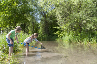 Germany, Bavaria, Munich, Girls with fishing net in lake - NH001409