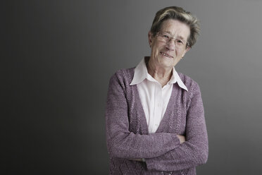 Portrait of senior woman standing with arms crossed, smiling, close up - JAT000089