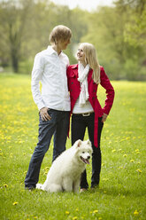 Deutschland, Junges Paar schaut sich mit Hund an, lächelnd - DSCF000088