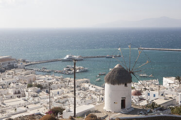 Griechenland, Mykonos, Blick auf Windmühle mit Hafen im Hintergrund - SKF001298