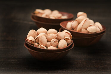 Bowls of pistachio on wooden table, close up - OD000177