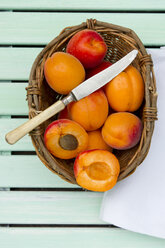 Apricots in basket with knife and napkin on table, close up - LVF000144