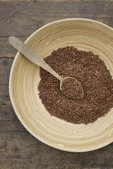 Bowl of lentils with wooden spoon on wooden table, close up - LVF000141