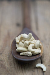 Cashew Nuts in wooden spoon on wooden table, close up - ASF005006