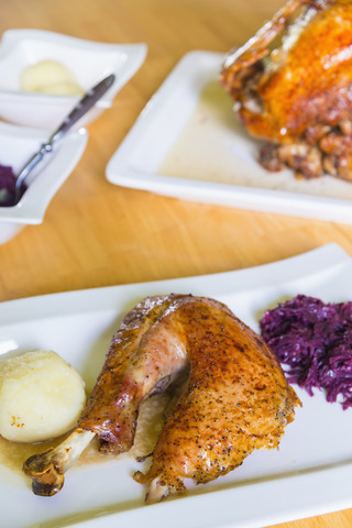 Roasted turkey leg with potato and red cabbage on dinner table, close up stock photo