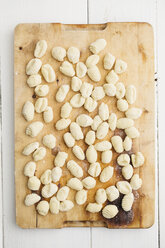 Uncooked gnocchi on chopping board, close up - ECF000256