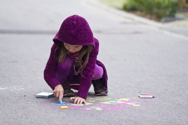 Deutschland, Mädchen malt mit Kreide auf der Straße - SARF000049