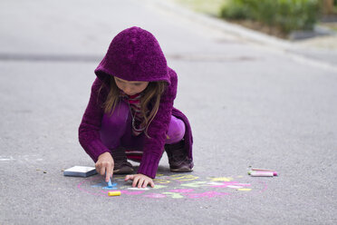 Germany, Girl drawing on street with chalk - SARF000049