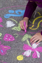 Germany, Girl drawing on street with chalk - SARF000047