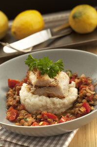 Schale mit rotem Fisch mit Zitronenrisotto und Linsen auf Holztisch, Nahaufnahme - OD000189