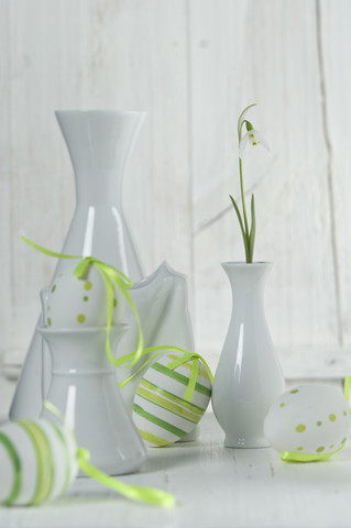 Schneeglöckchen in Vase mit Ostereiern auf Holztisch, Nahaufnahme, lizenzfreies Stockfoto