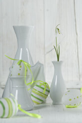 Schneeglöckchen in Vase mit Ostereiern auf Holztisch, Nahaufnahme - ASF005029