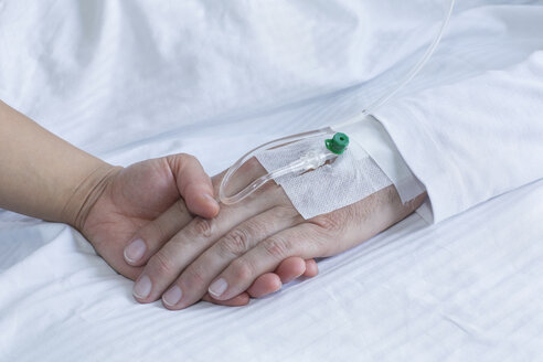 Deutschland, Freiburg, Frau hält Hand eines Mannes im Krankenhaus, Nahaufnahme - DRF000022