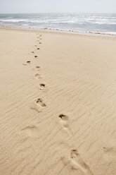 Spain, Footsteps on sand at beach - SKF001381