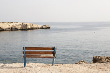 Italy, Sardinia, Empty bench near coast - SKF001333