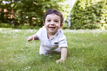 Baby boy crawling on grass, smiling - MFF000556