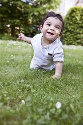 Baby boy crawling on grass, smiling - MFF000557