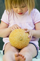 Germany, Bavaria, Girl holding galia melon, close up - LVF000155