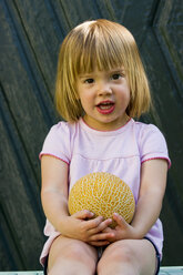 Germany, Bavaria, Portrait of girl holding galia melon, close up - LVF000154