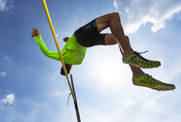 Germany, Man athlete jumping Hurdles on track - STSF000060