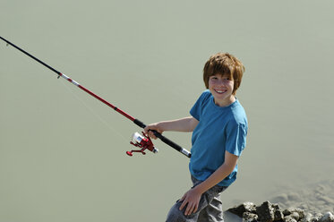 France, Boy holding fishing rod, smiling - LBF000164