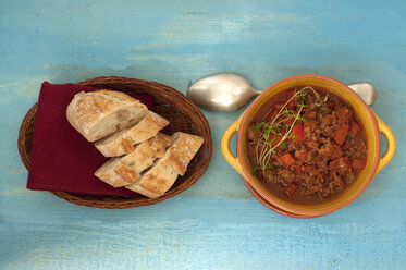 Sauce with raw hash, tomato and baguette on wooden table, close up - OD000245