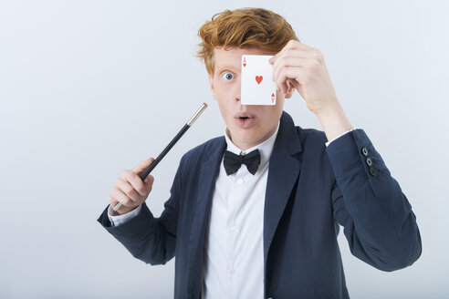 Portrait of young man showing magic of cards - TCF003475