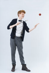 Junger Mann zeigt Magie mit Ball, lächelnd - TCF003494
