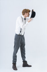 Young man showing magic with hat - TCF003505