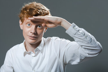 Portrait of young man shielding eyes, close up - TCF003466