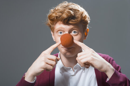 Porträt eines jungen Mannes, der einen Ball auf der Nase hält, Nahaufnahme - TCF003464