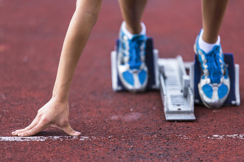 Deutschland, Junge Frau läuft vor dem Sprintstart - STSF000082