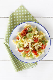 Teller mit Fenchel-Tomaten-Nudeln auf Holztisch, Nahaufnahme - EVGF000144