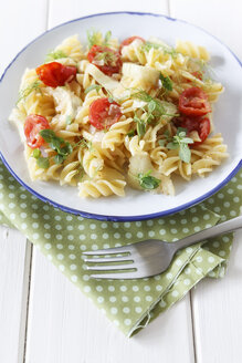 Teller mit Fenchel-Tomaten-Nudeln auf Holztisch, Nahaufnahme - EVGF000156