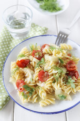 Teller mit Fenchel-Tomaten-Nudeln auf Holztisch, Nahaufnahme - EVGF000145