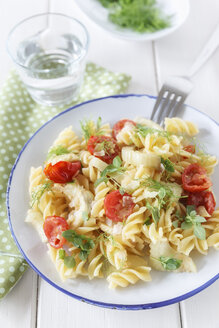 Teller mit Fenchel-Tomaten-Nudeln auf Holztisch, Nahaufnahme - EVGF000145